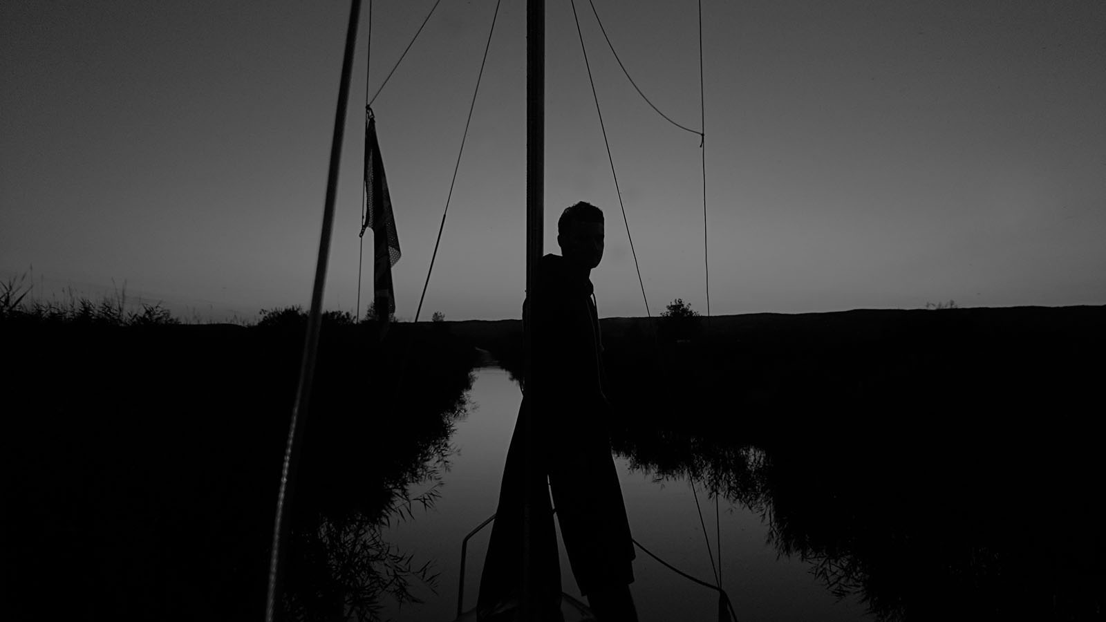 Abendliche Szene auf einem Segelboot in einem ruhigen Schilfkanal