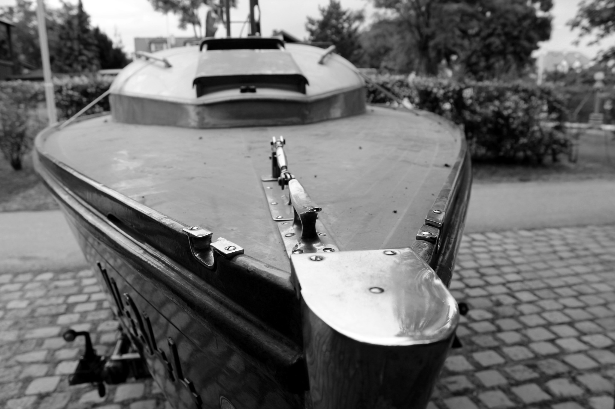 Bug eines klassischen Segelbootes mit Holzdeck und Metallbeschlägen in Schwarz-Weiß