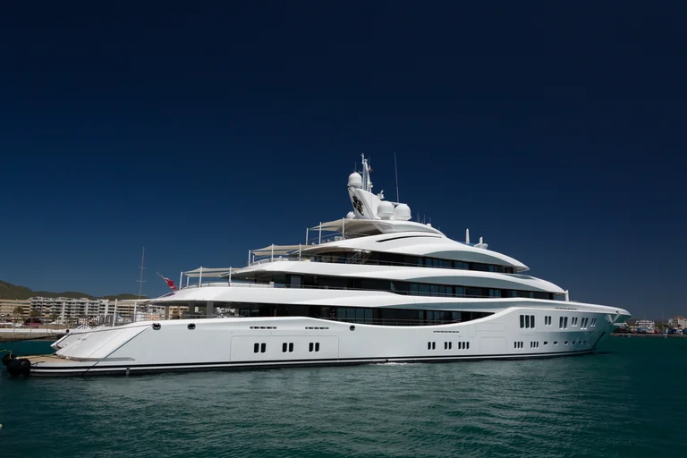 Große weiße Motoryacht mit mehreren Decks und hochwertigem Aufbau im Hafen